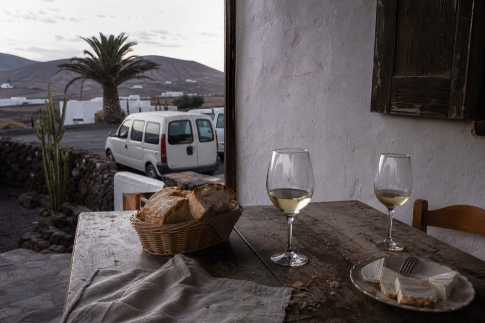 A simple Canarian bar table with bread, cheese and a glass of white wine