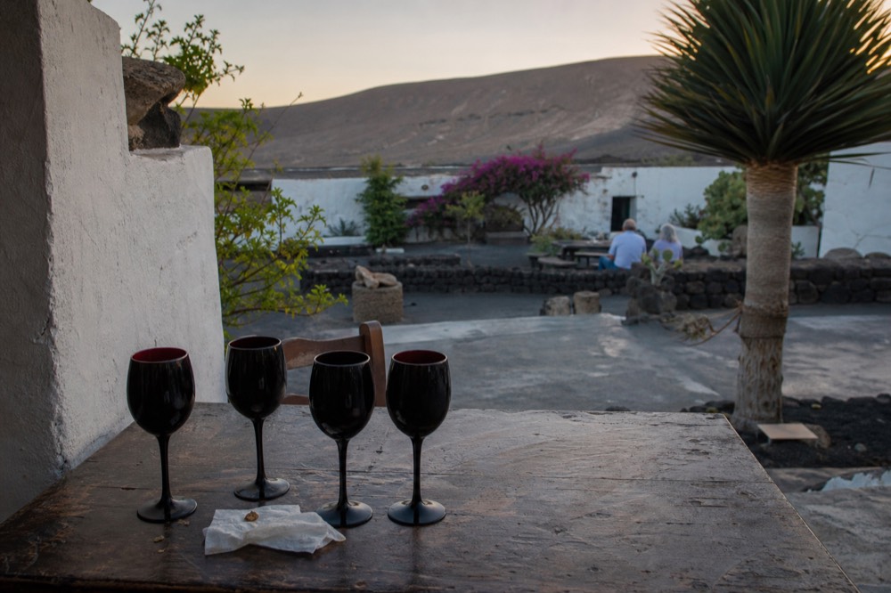 A blind wine tasting flight in black glasses on a wooden table