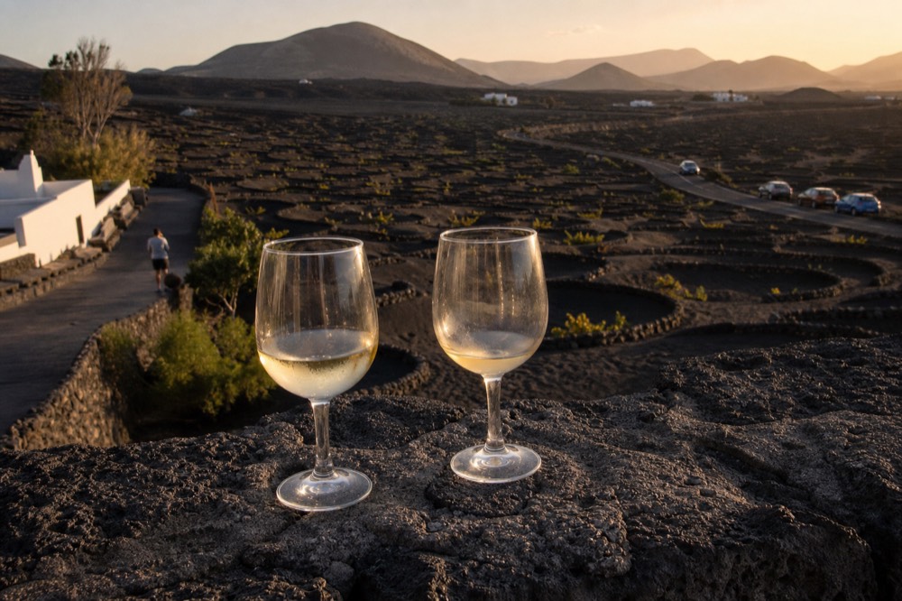 Wine glasses on a winery terrace facing volcanic cones