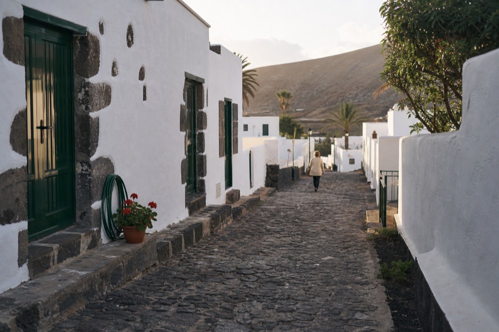 Cobbled street with whitewashed houses and green wooden doors in a Canarian town