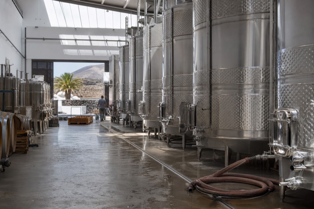 Rows of modern stainless steel tanks inside a bright Lanzarote winery