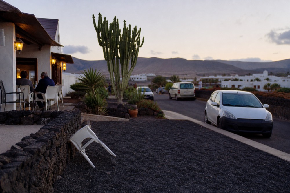 A village bar terrace in the Lanzarote interior with white walls and black volcanic gravel