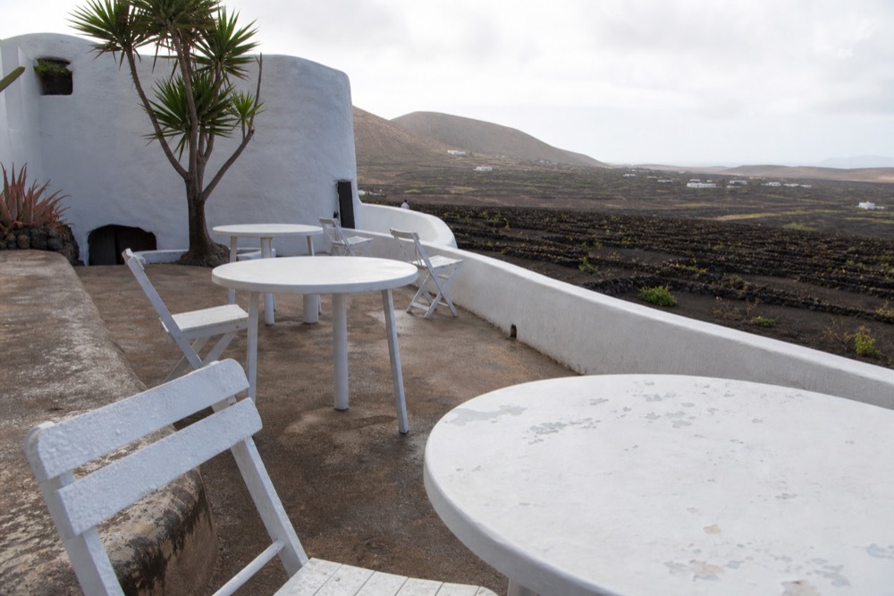 Empty winery terrace in morning light overlooking rows of volcanic ash vine pits