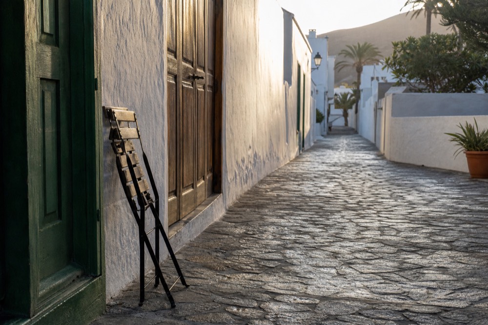 A whitewashed historic town street with wooden doors and quiet morning light