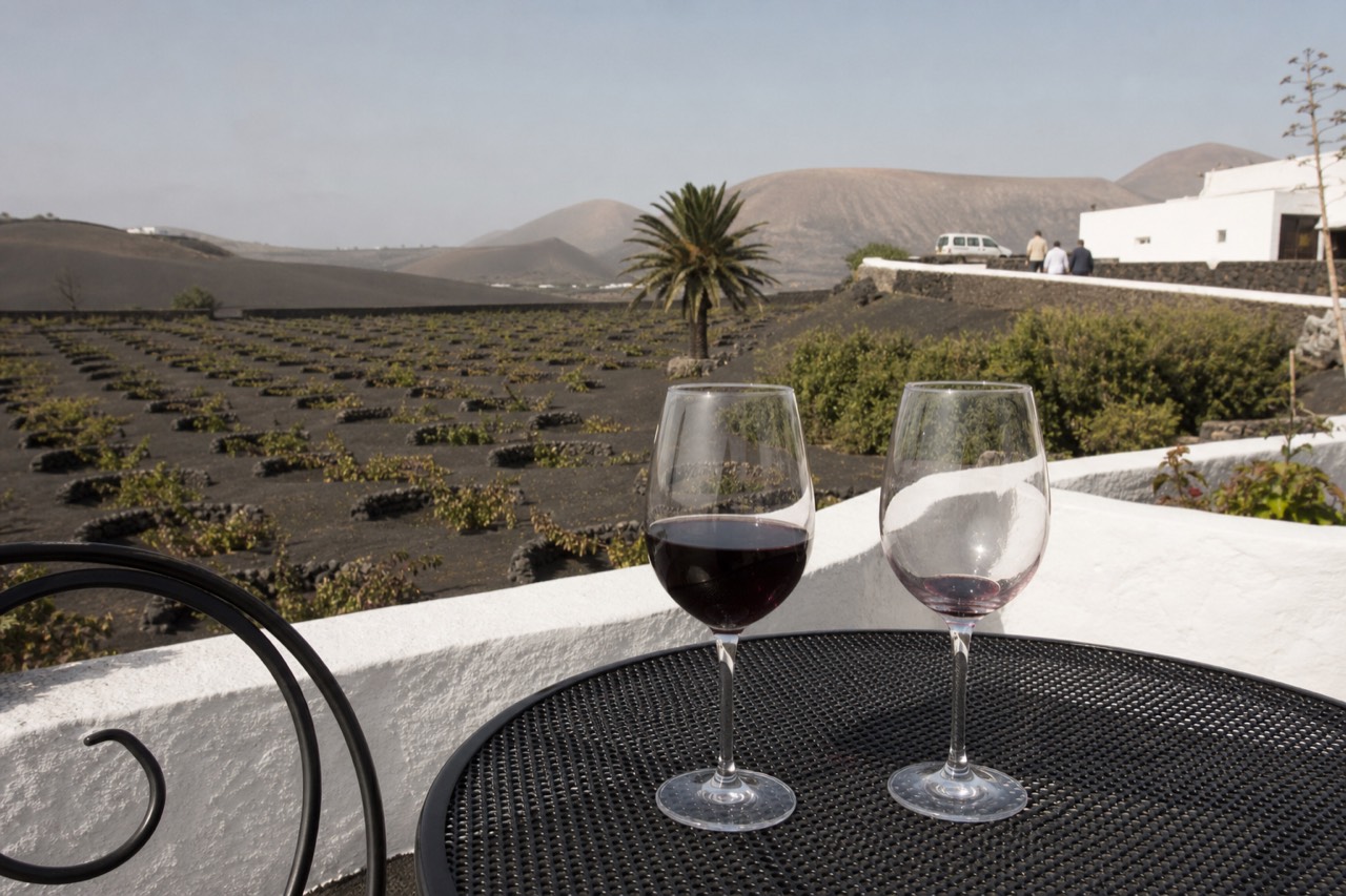 Wine glasses on a table overlooking La Geria vineyards
