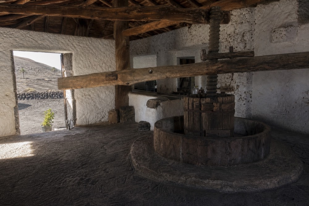 Old stone wine press and wooden beams inside an 18th century Canarian bodega