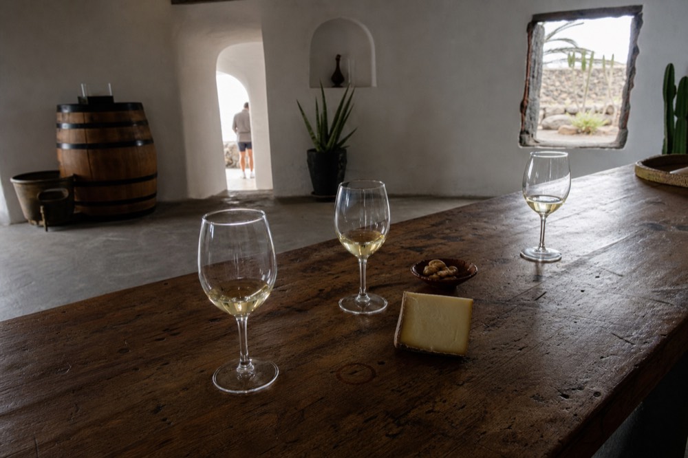 Glasses of pale white wine on a wooden tasting table
