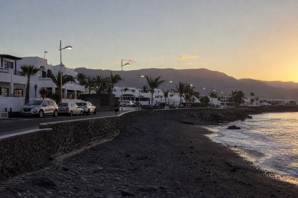 Coastline of Puerto del Carmen resort with volcanic hills behind