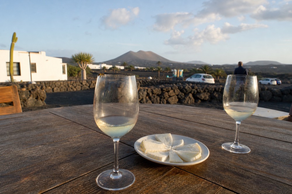 Wine glasses and artisan cheese plate on a bodega terrace in La Geria